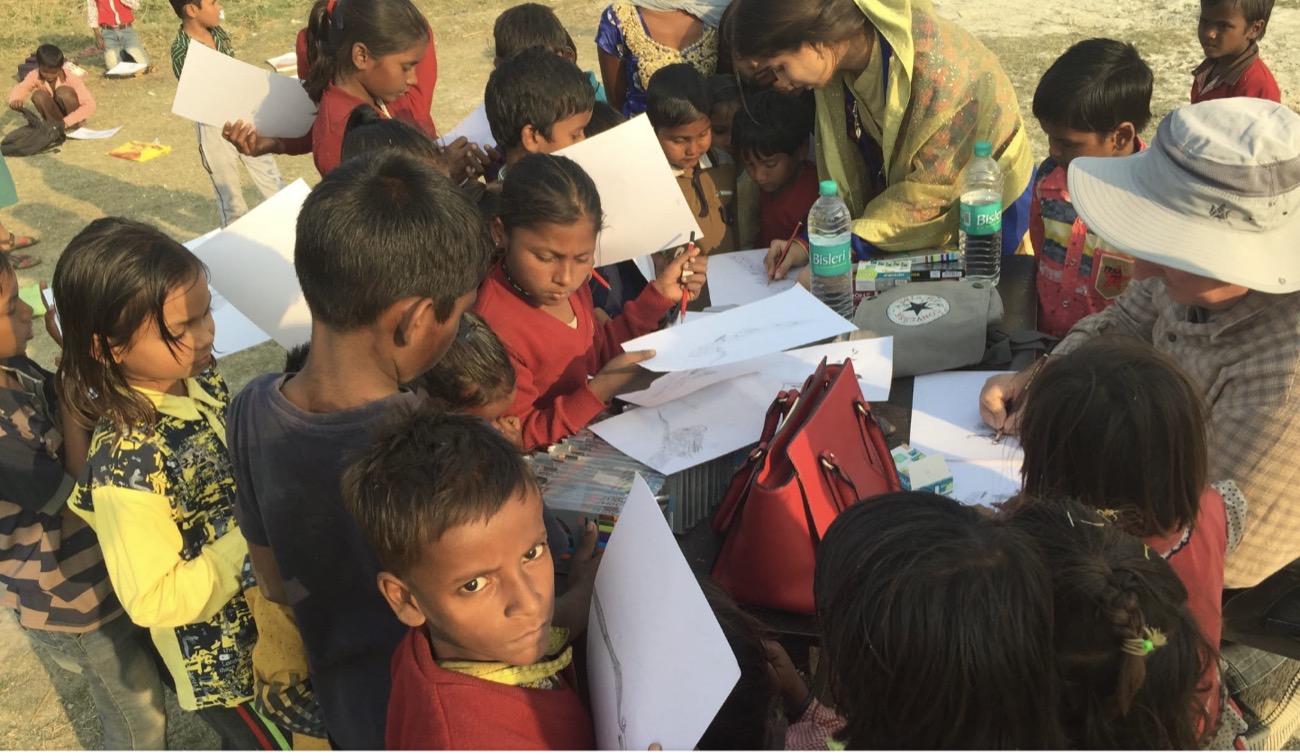 Children gather round an art table