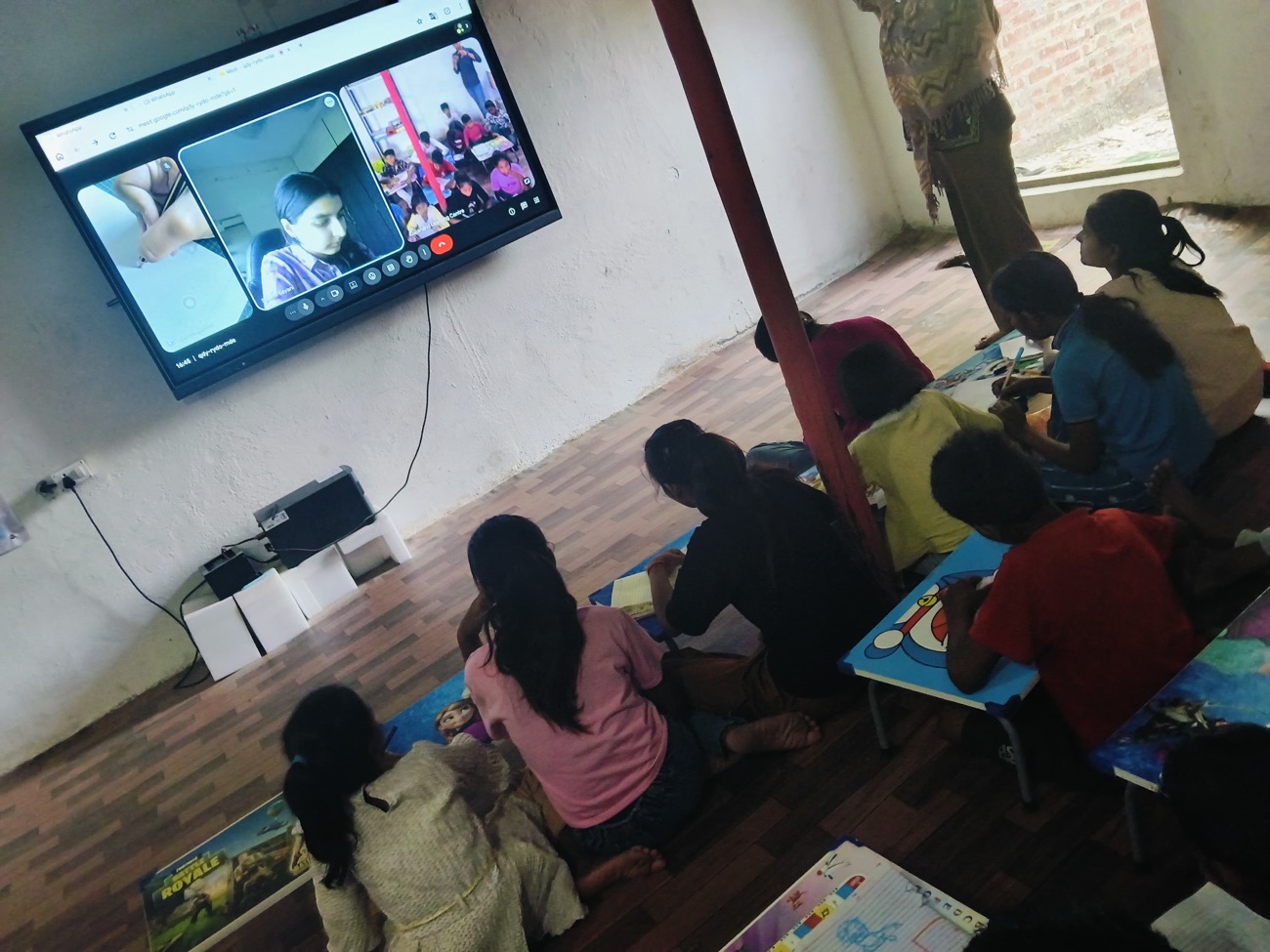 Children watching a video call with the Gajanand Learning Centre team on the smartboard