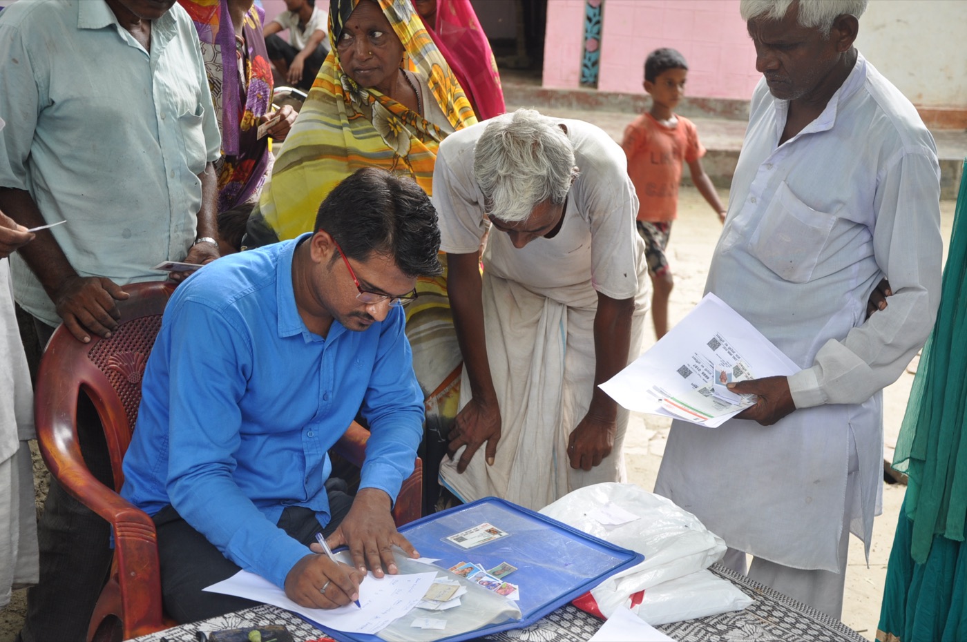 Volunteers helping villagers fill out PAN card forms